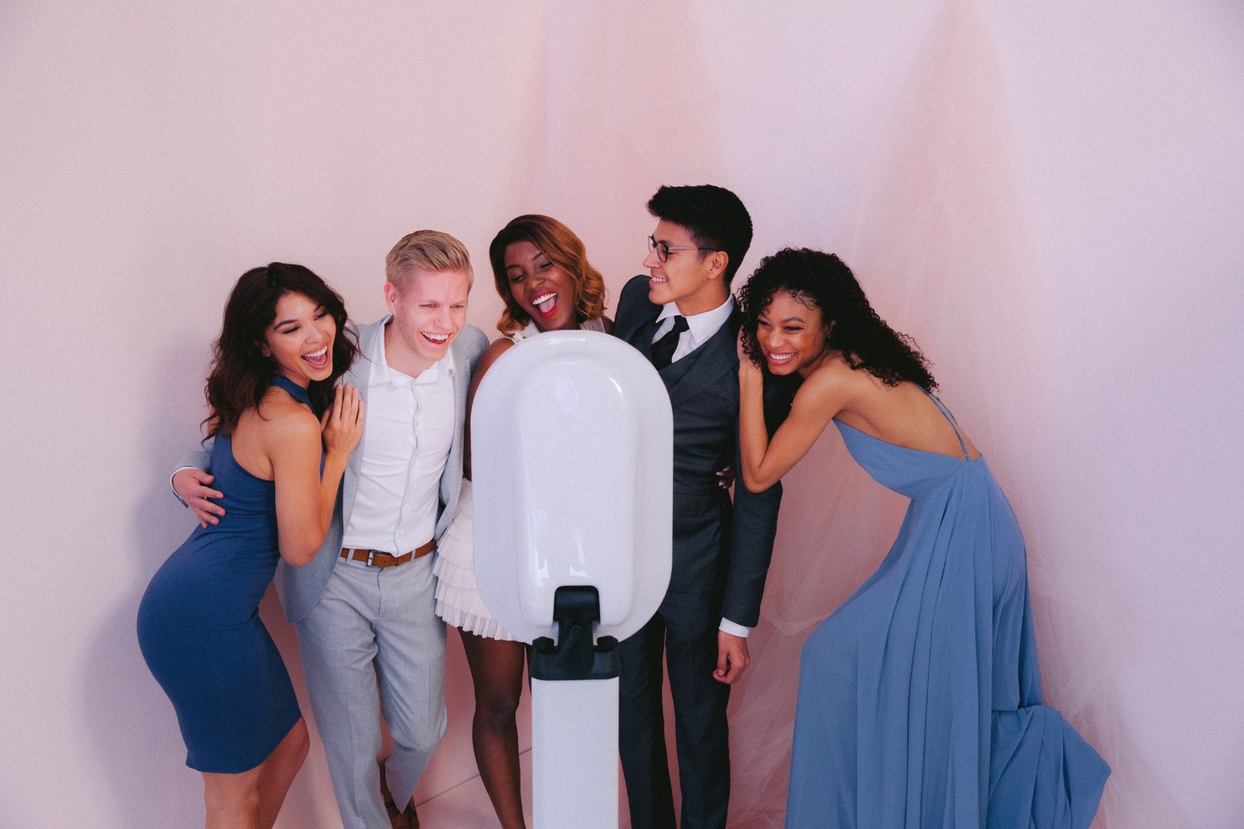 Formal group smiling at a pink backdrop event